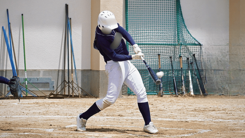 バットにボールが当たった瞬間を捉えた少年野球の打席
