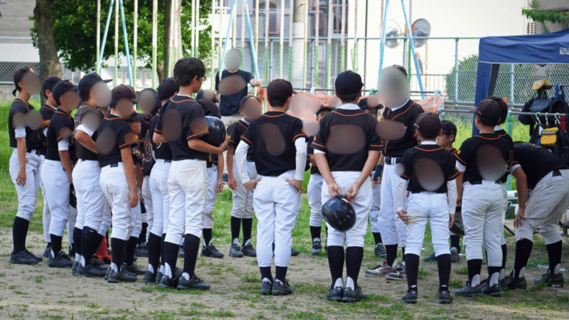 試合後のミーティングで話を聞く少年野球の選手たち