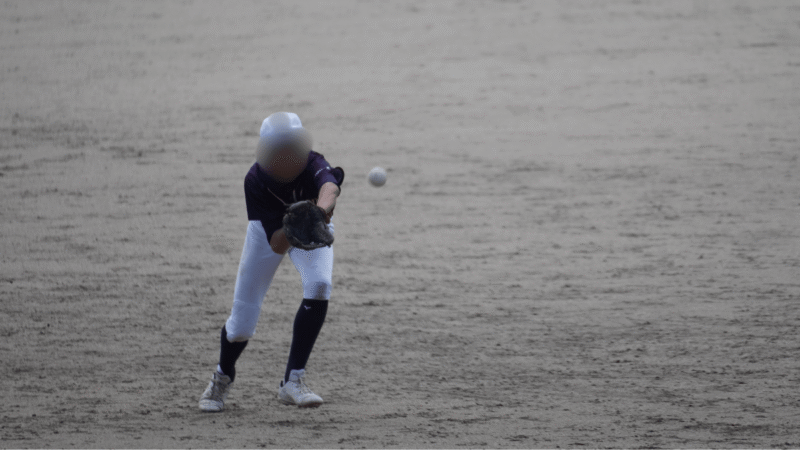 曇天の試合で、全体が青っぽく沈んでいる外野手の写真