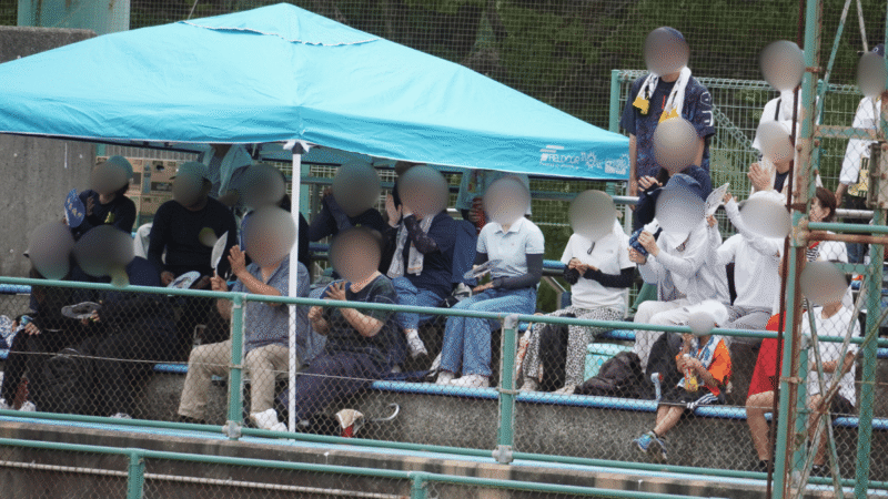 少年野球の応援席で得点に喜ぶ保護者たち