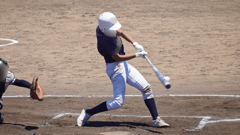 バットにボールが当たった瞬間を捉えた少年野球の打席