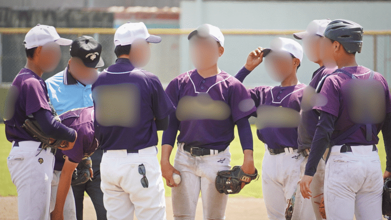 タイムがかかりマウンドに集まる少年野球の監督と内野の選手たち