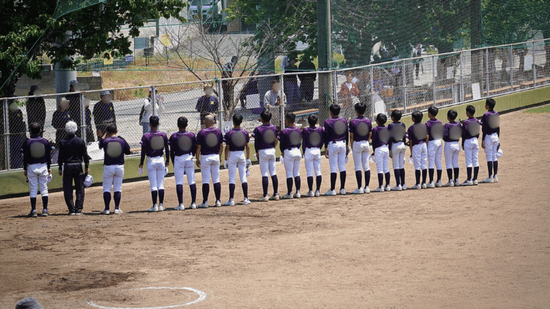 少年野球の遠征試合で初めて訪れた球場のフェンスに囲まれた応援席の様子
